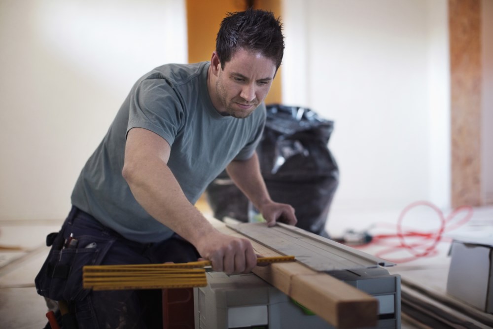 Mann som høvler en planke