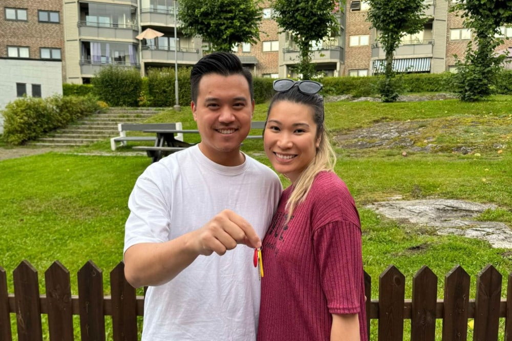 Et par som står ute og smiler