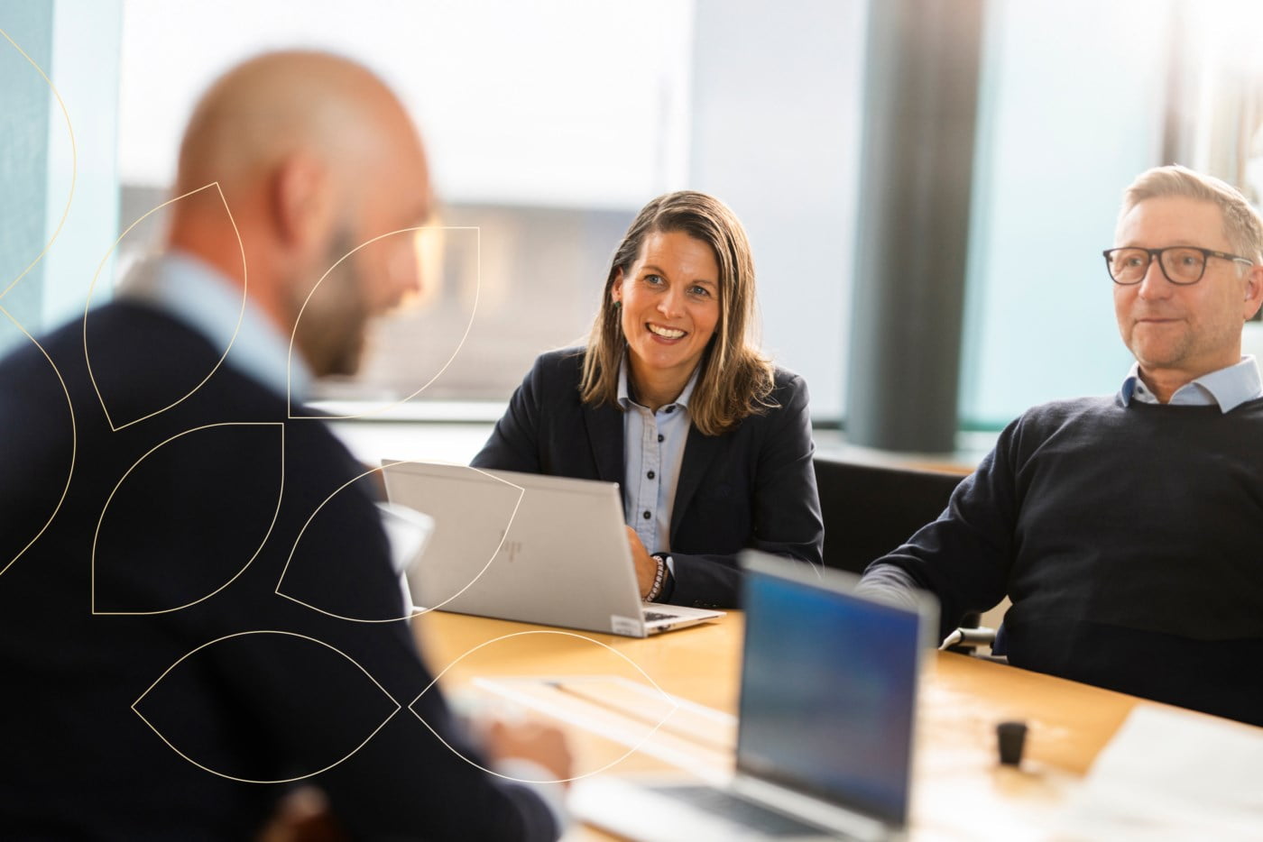 Tre rådgivere snakker sammen ved et møtebord
